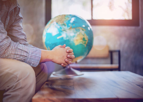 a child praying with a globe beside him