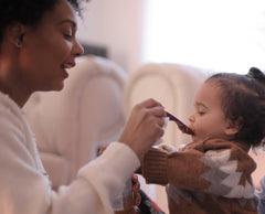 Woman Feeding A Child With a Spoon