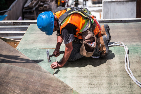 Construction worker in a safety vest hammering nails