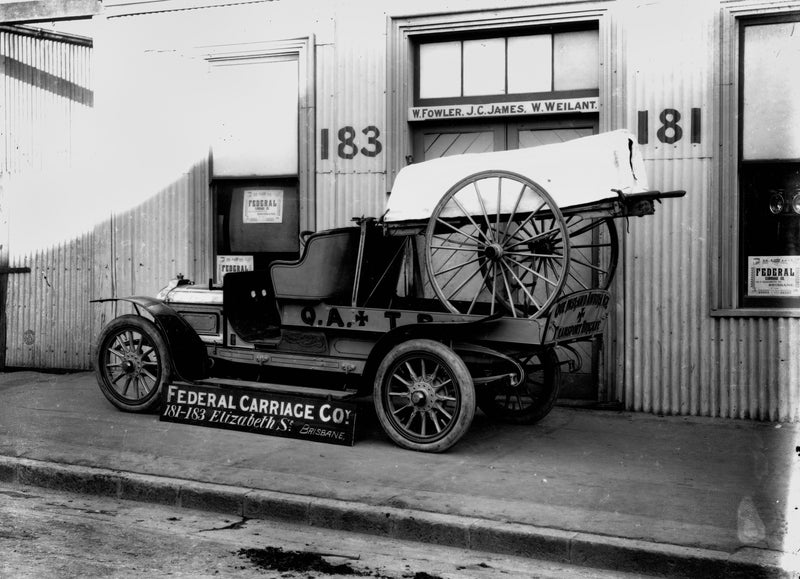 Early motor ambulance and wheeled stretcher in front of the Federal Carriage Co. premises, Brisbane, 1912