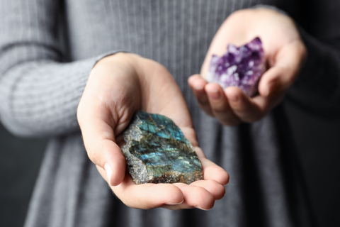 Woman holding labradorite and amethyst crystals in her hands