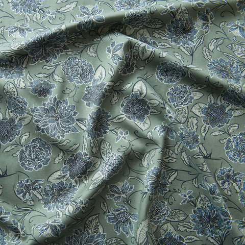 Sage green viscose dressmaking fabric with flowers across it