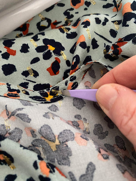 Using tweezers to remove the lurex thread from around the inside of the neck