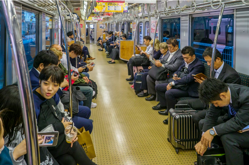 people on a train looking down on their smartphone