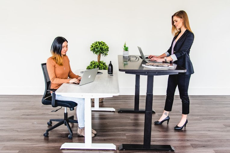 two women using a standing desk