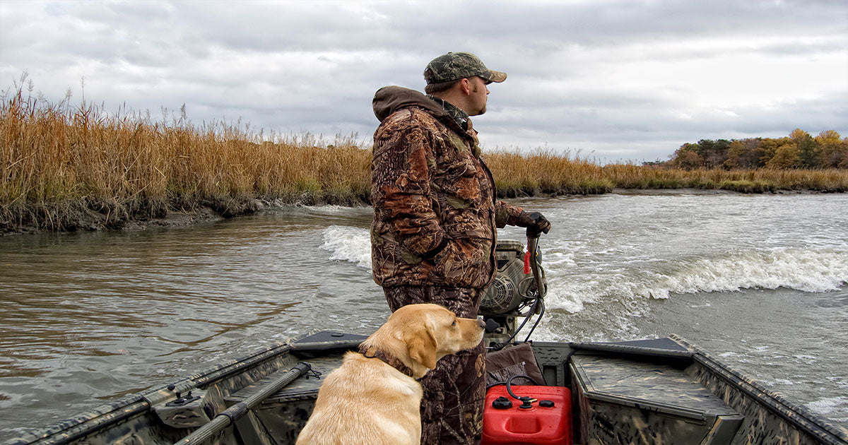 Man on boat with dog while hunting