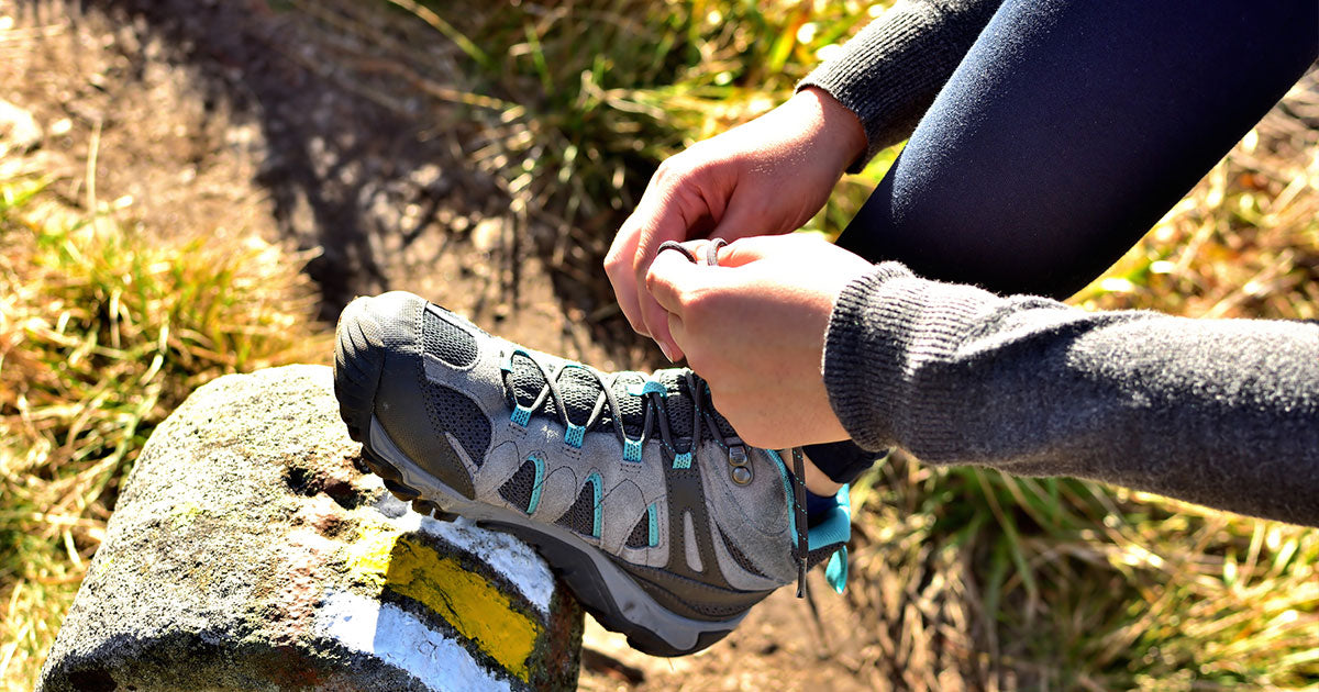 Woman on hike tying shoe