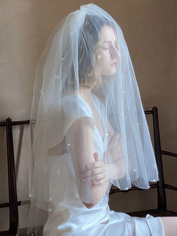 https://cdn.shopify.com/s/files/1/0252/9823/9585/files/classic-ivory-two-tier-pearls-tulle-cut-edge-wedding-veil-wedding-veils_600x.jpg?v=1701982978