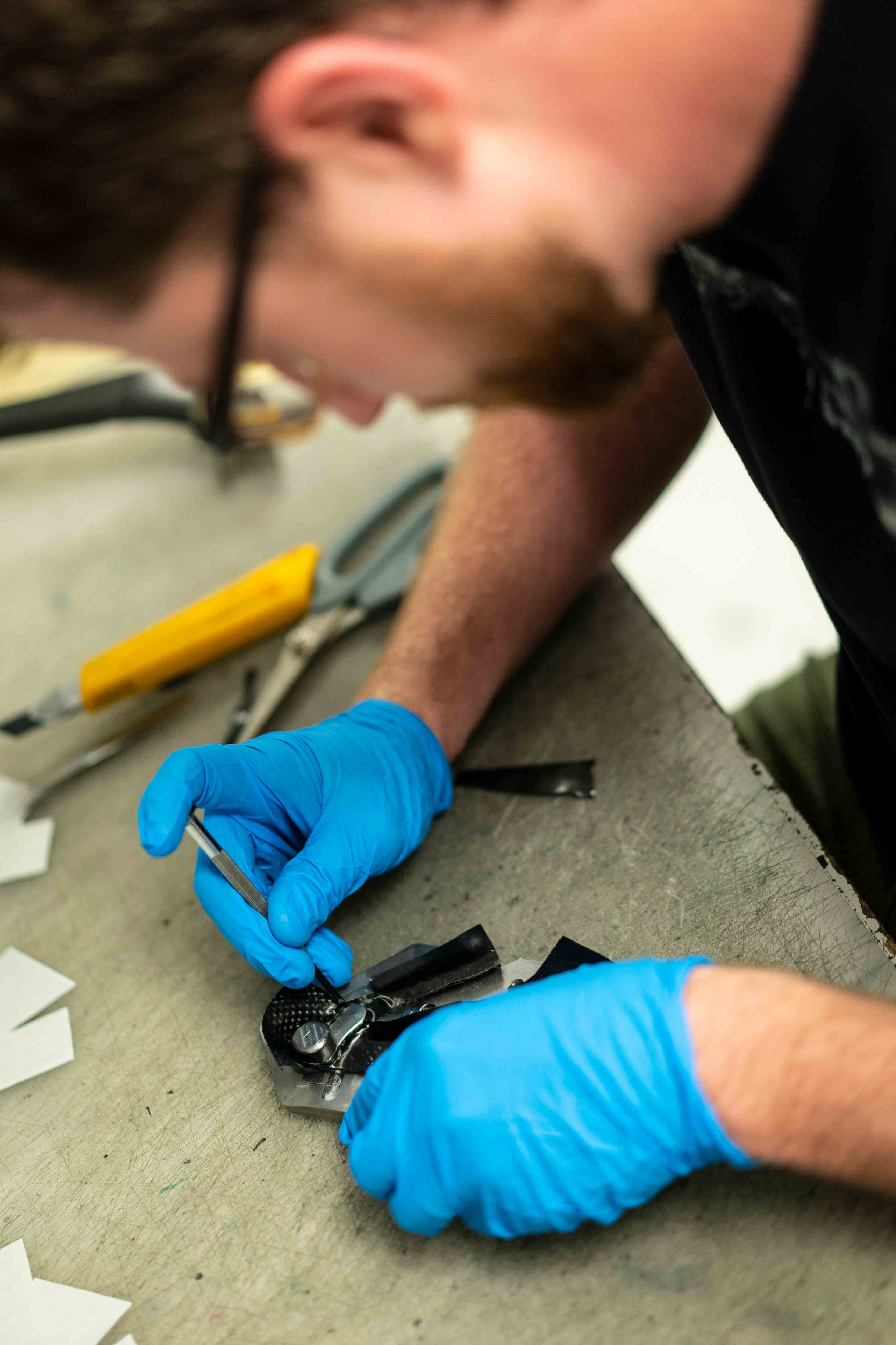 A technician working on a small bike component at a workbench