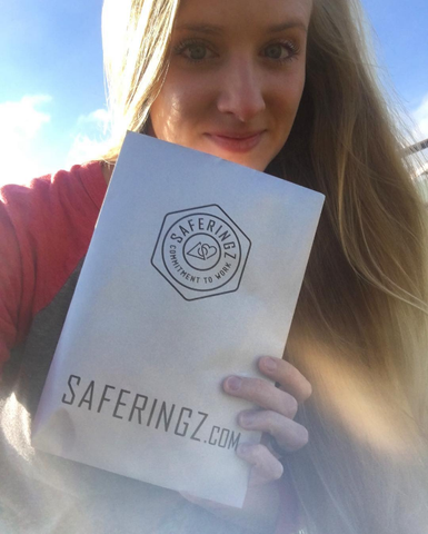 A blonde woman holding up a SafeRingz pamphlet.