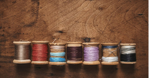 Premium Photo  Spool of brown string in hand on brown background