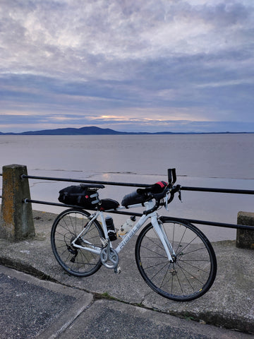 Touring bike by the sea loaded with bike luggage