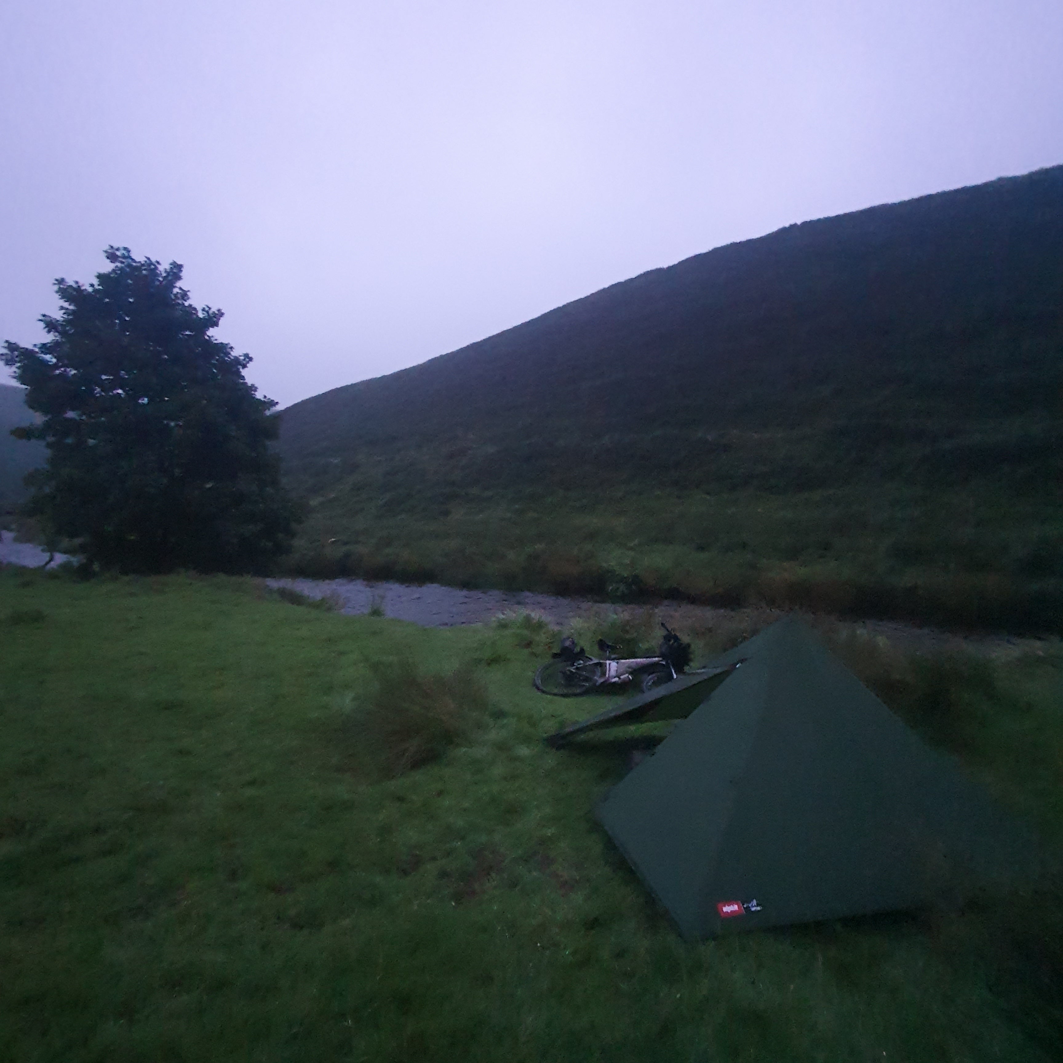 camping set up next to a stream of running water