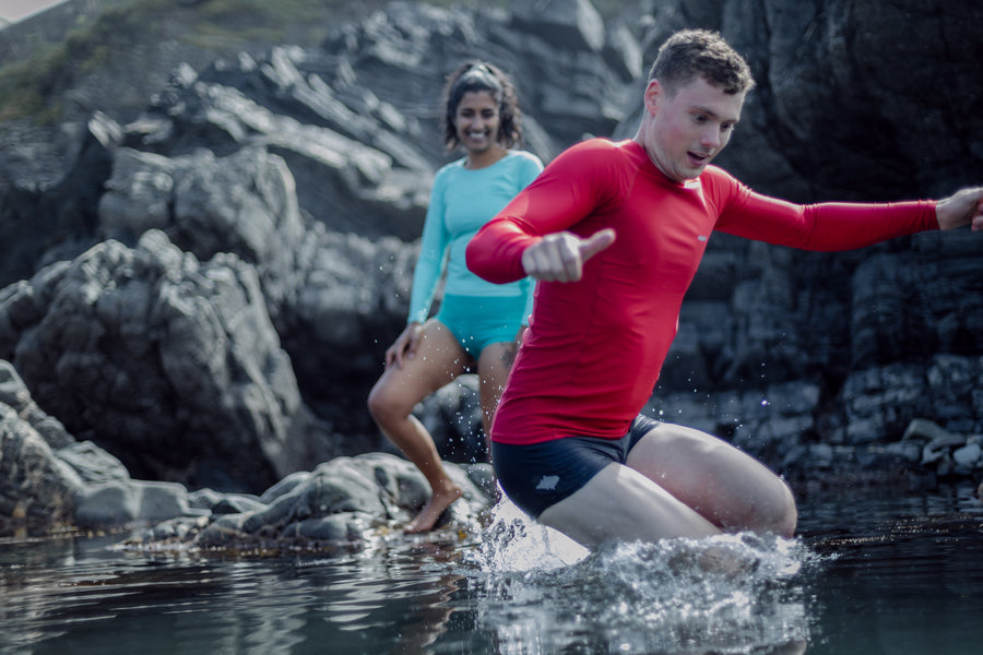 couple smiling and jumping in water