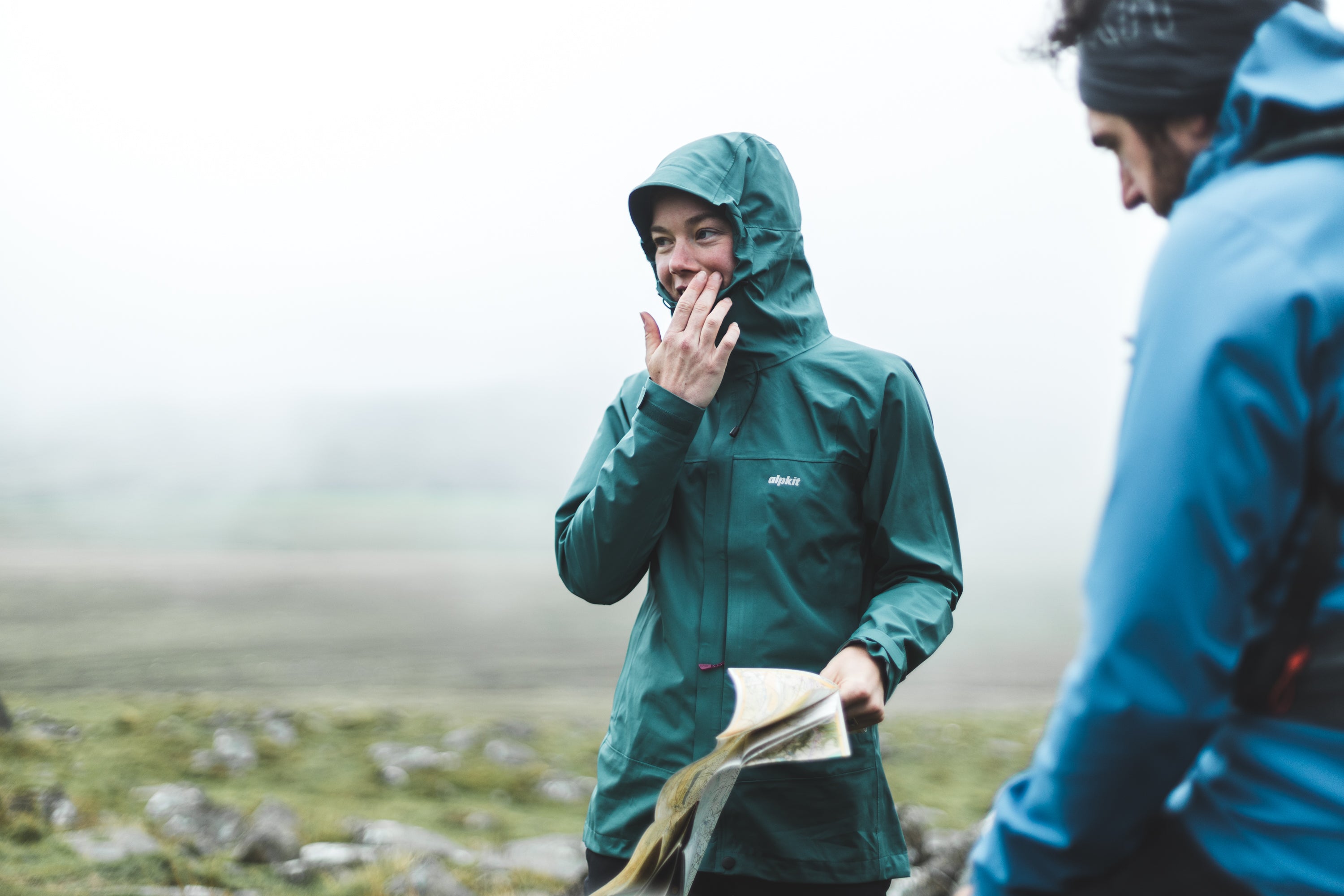 A woman trying to read a map on Dartmoor, wearing a PFC free waterproof jacket