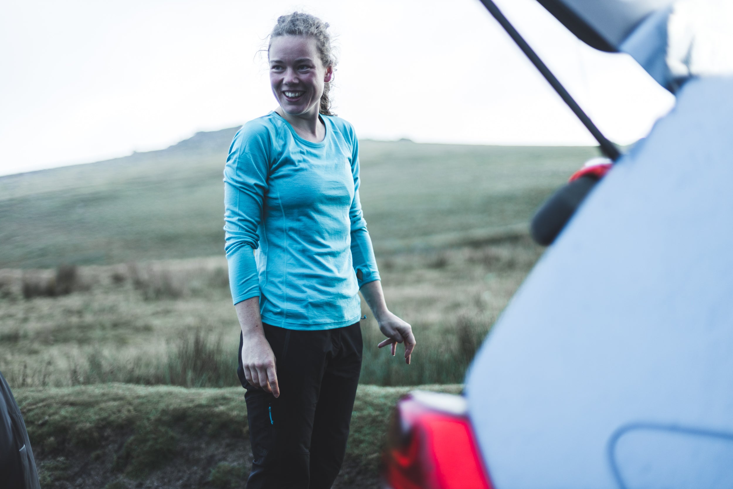 Long sleeved merino base layer getting changed by the car for trail running