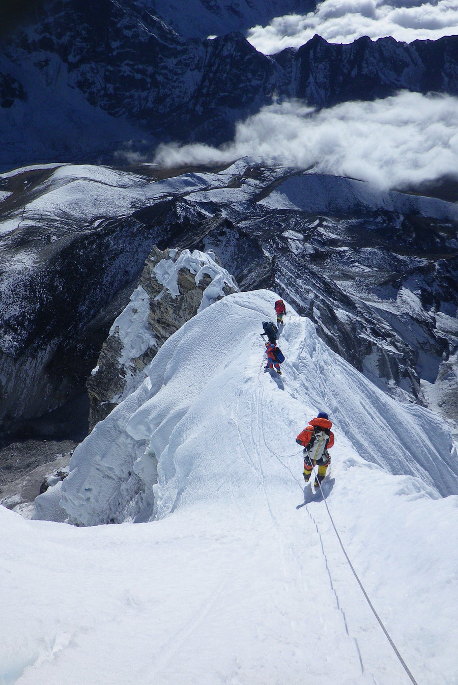 Trekkers traversing a snowy himalayan ridgeline