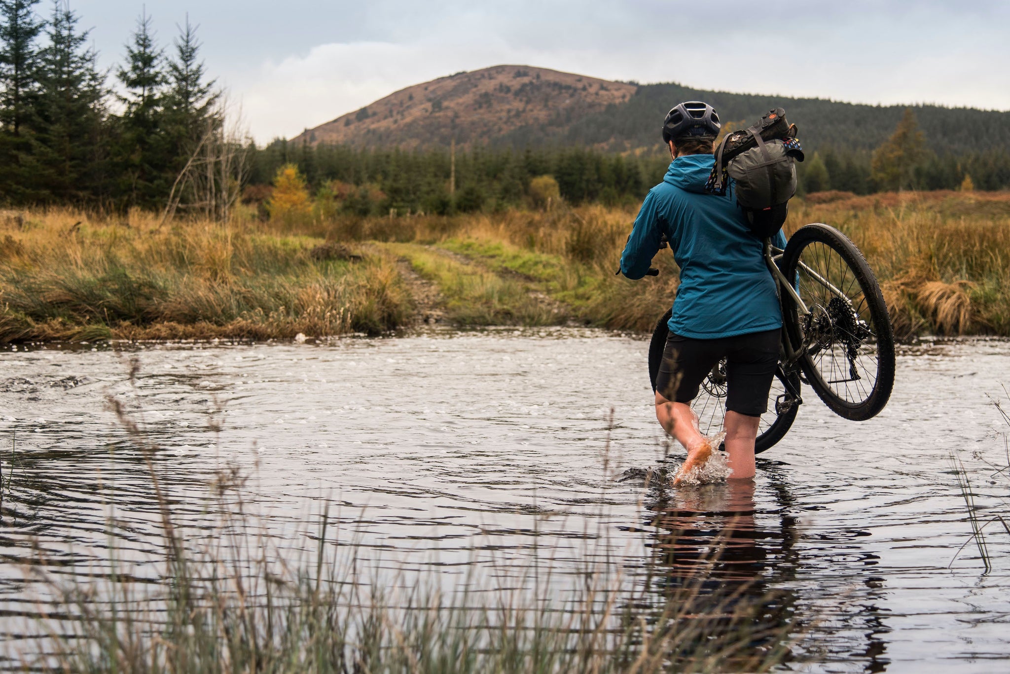 Fording a river while bikepacking in Galloway Forest