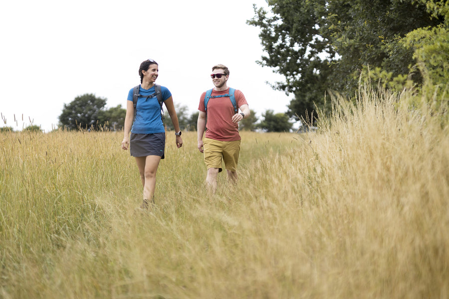 a man and woman walking in a field, the woman is wearing the Aiguille skort