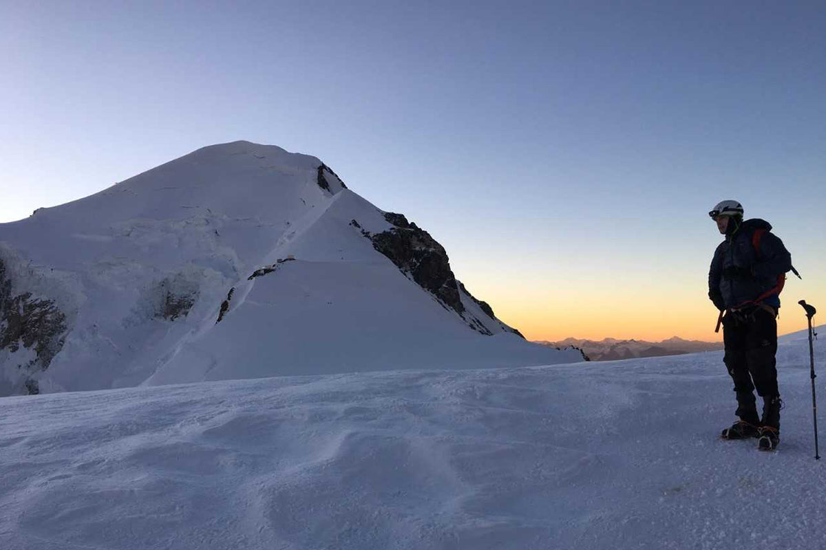 Climber standing on snowy mountain summit