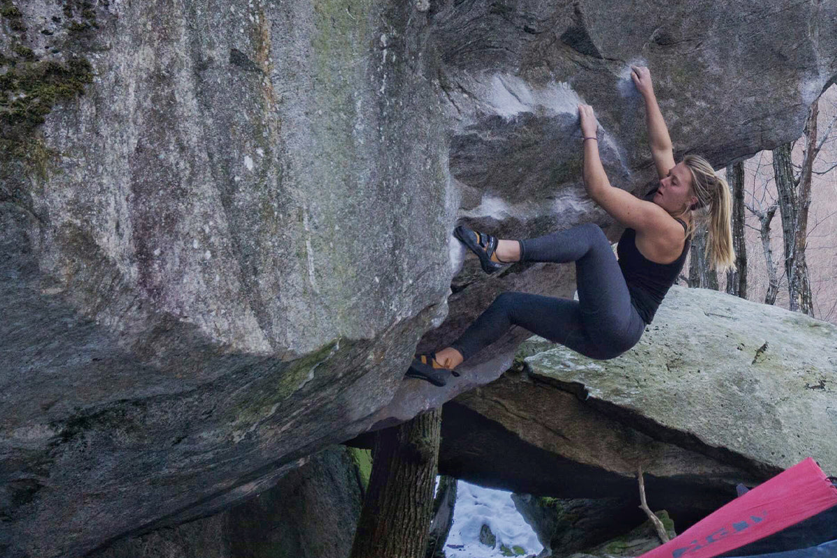 Woman bouldering over a boulder mat