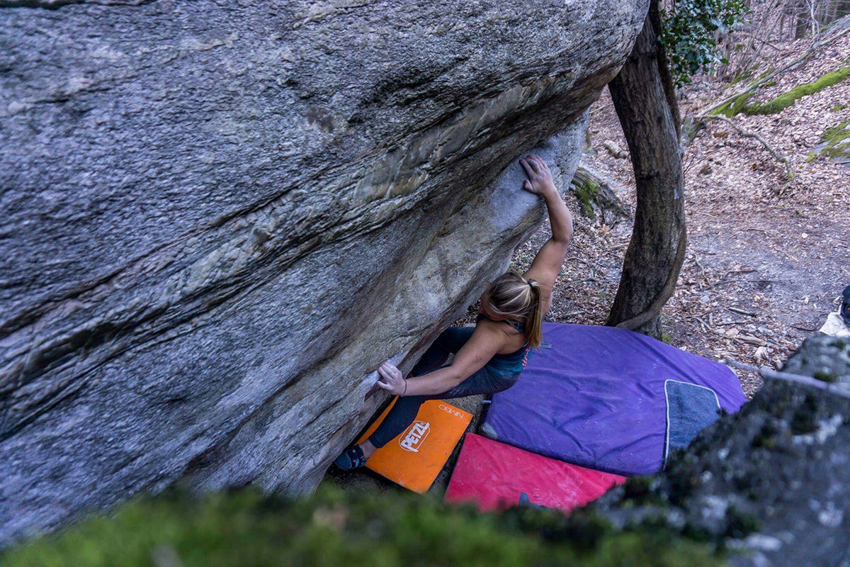 Girl traverses over bouldering mats