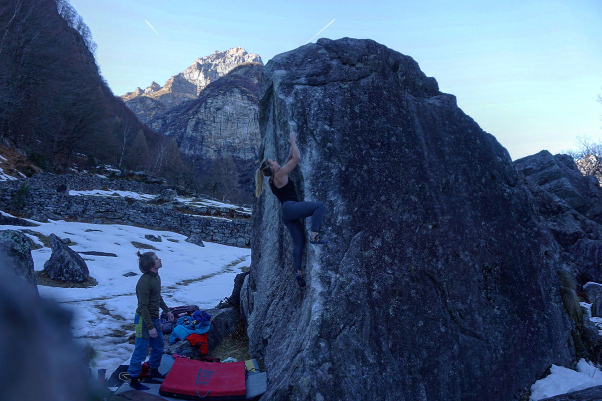 Woman bouldering over a bouldering mat