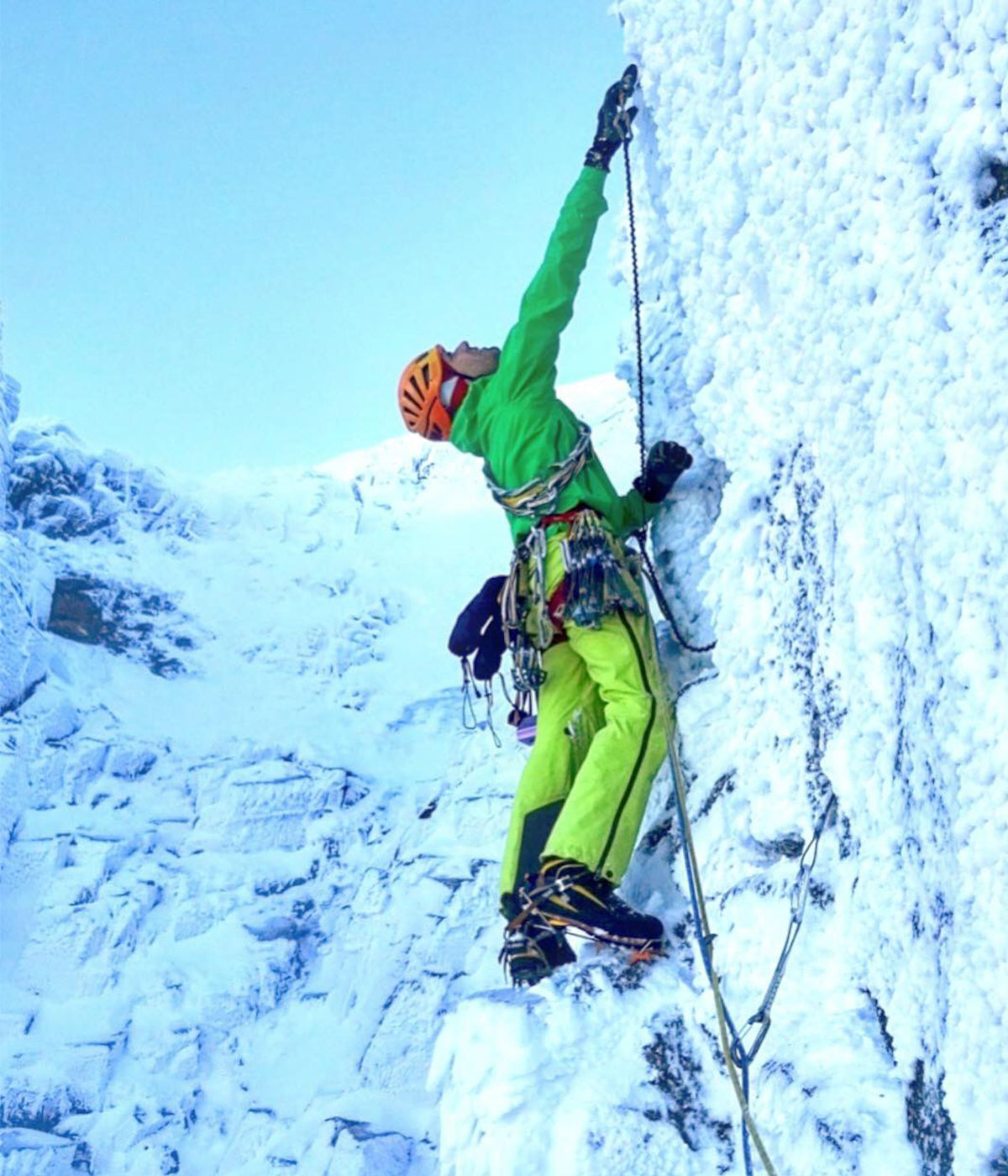 Climber looks for holds on steep Scottish mixed climb