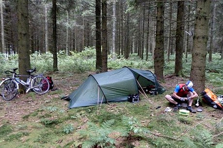 Bikepackers sitting outside hooped tunnel tent