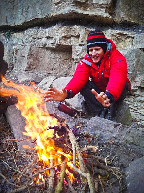 Tim Emmett taking a break from drytooling warming himself by a fire