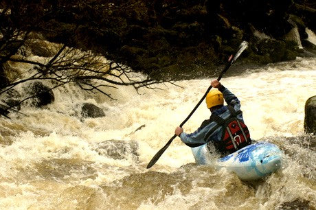 Kayaker navigating fast flowing river
