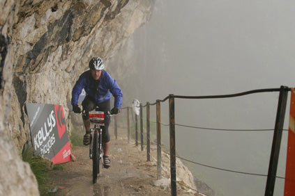 Mountain biker races along narrow mountain path