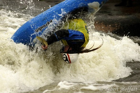 Playboater rolls his kayak in playwave