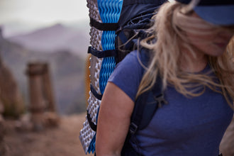 A woman backpacking in Mallorca with an ultralight folding foam mat