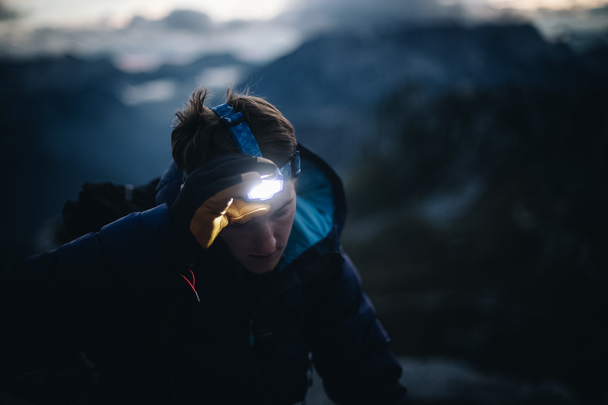 Pressing on the Muon head torch in the Slovenian mountains with gloves on