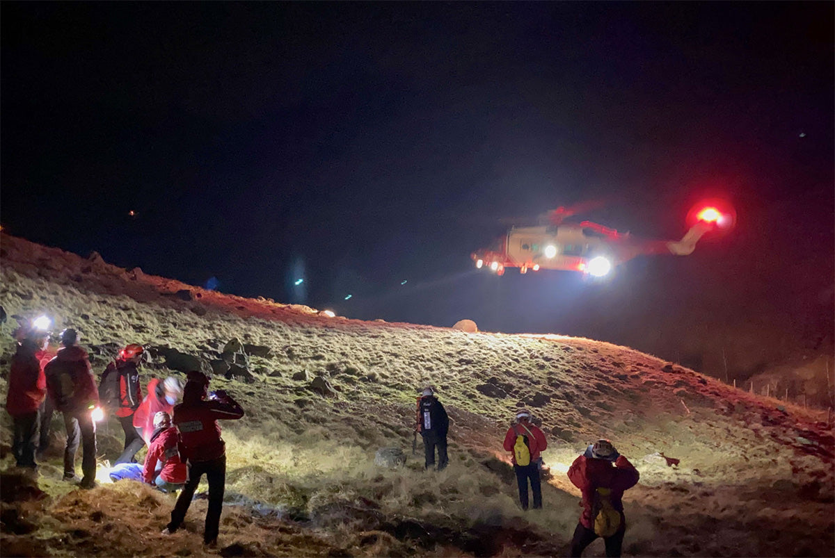 Mountain rescue helicopter landing by mountain rescue team at night