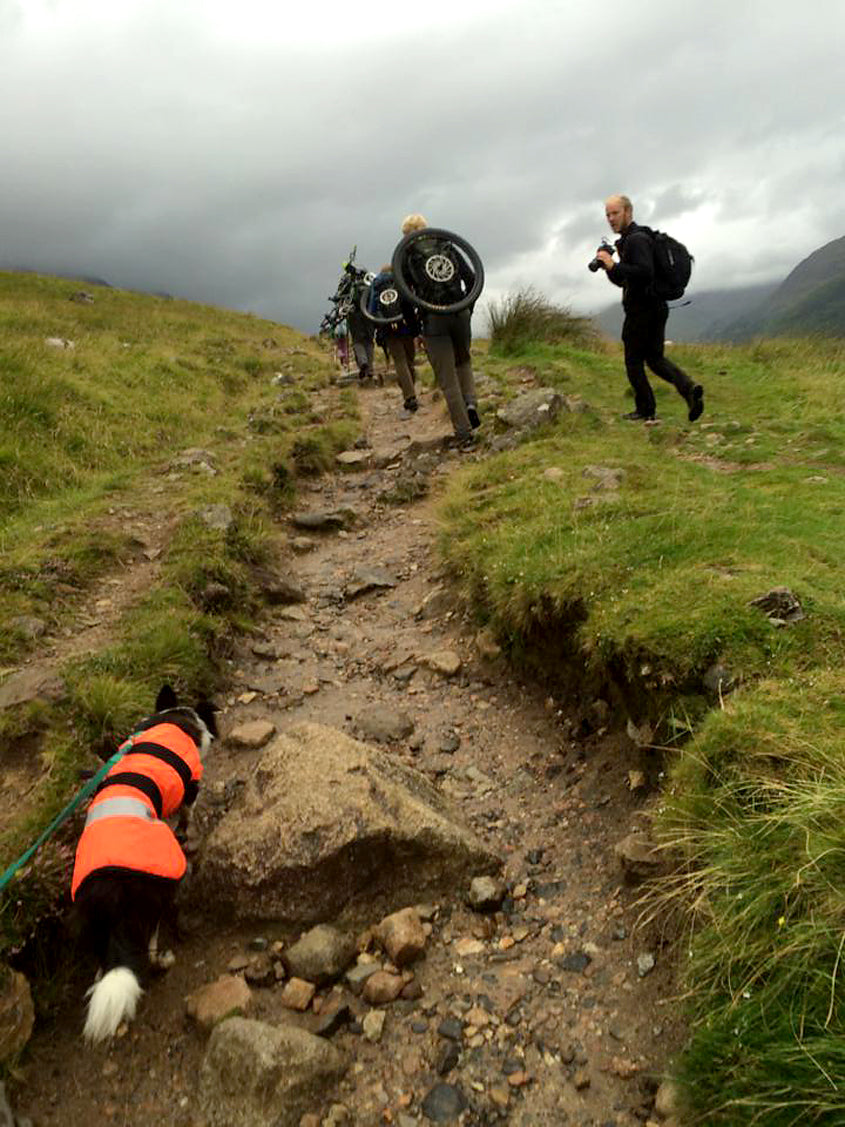 Hikerbikers carrying their bikes up a mountain trail