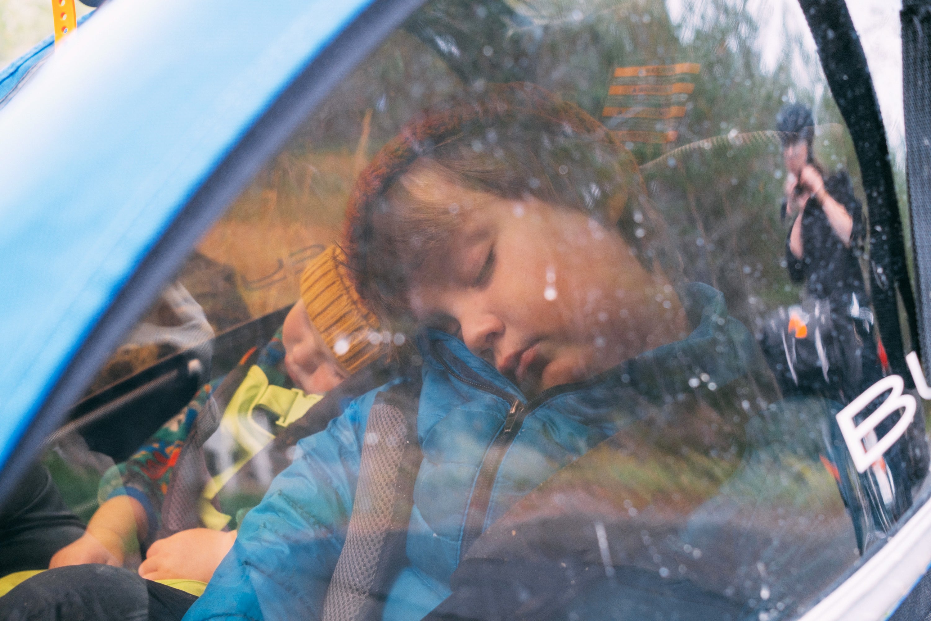 child asleep in a tow along bike trailer