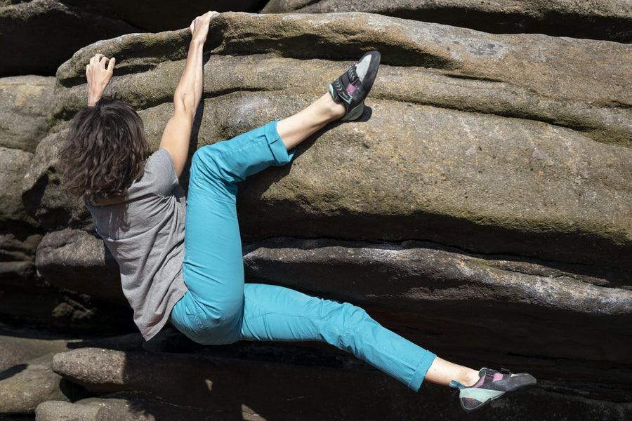 woman bouldering in organic cotton trousers