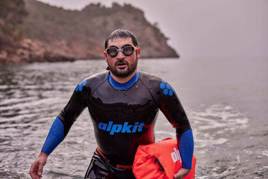 Open water swimmer in goggles emerges from sea