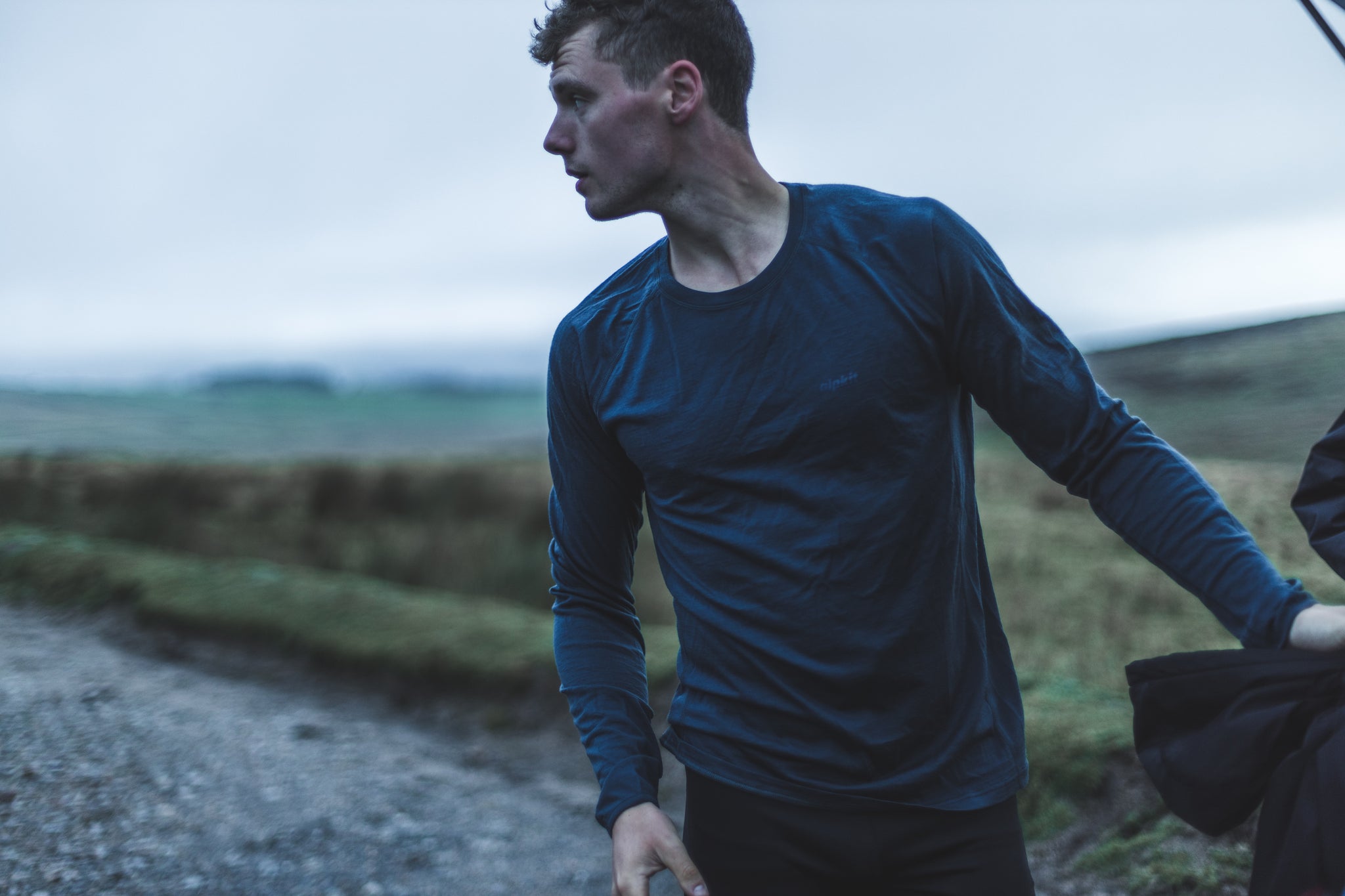 A man getting changed after a run in a long sleeved Merino base layer