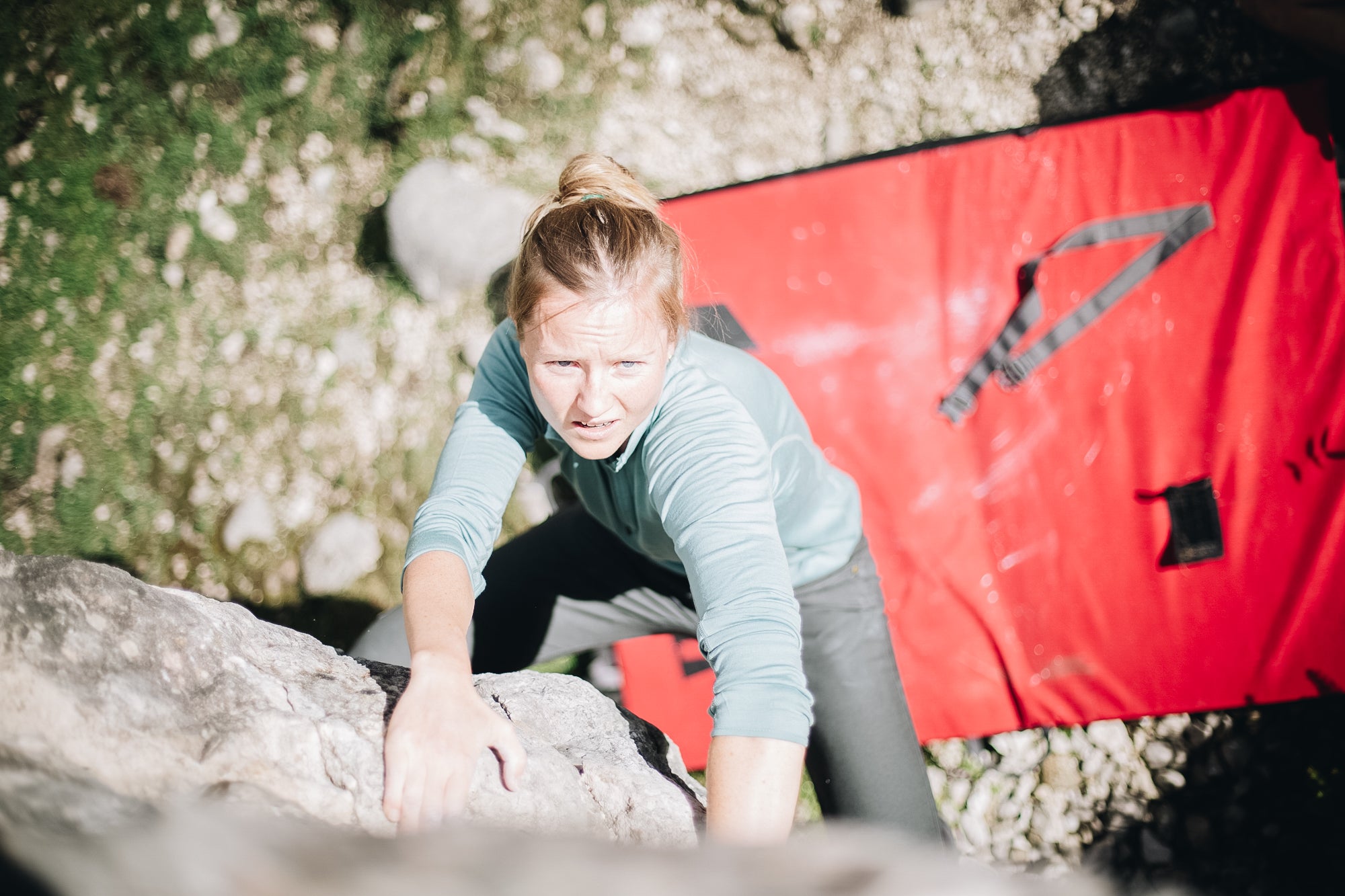 Woman bouldering in merino wool in Slovenia