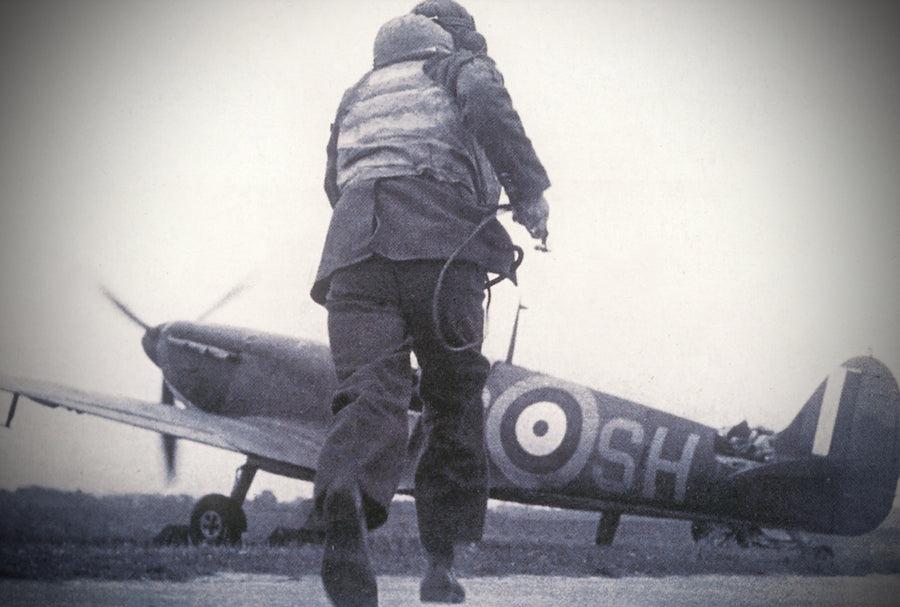 An RAF fighter pilot getting into a Spitfire wearning a Ventile® immersion suit