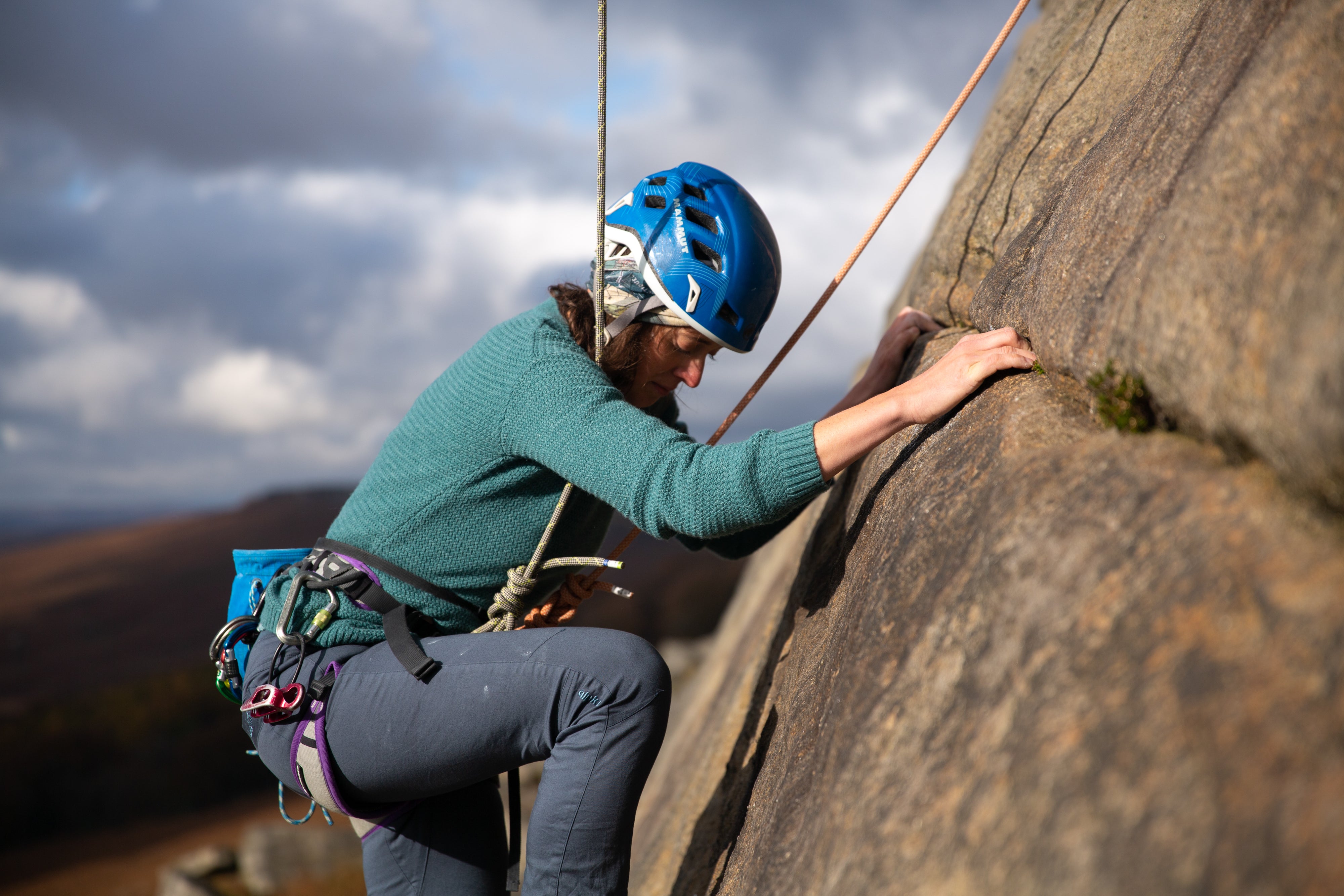 A woman trad climbing on Stanage Edge in the Peak District