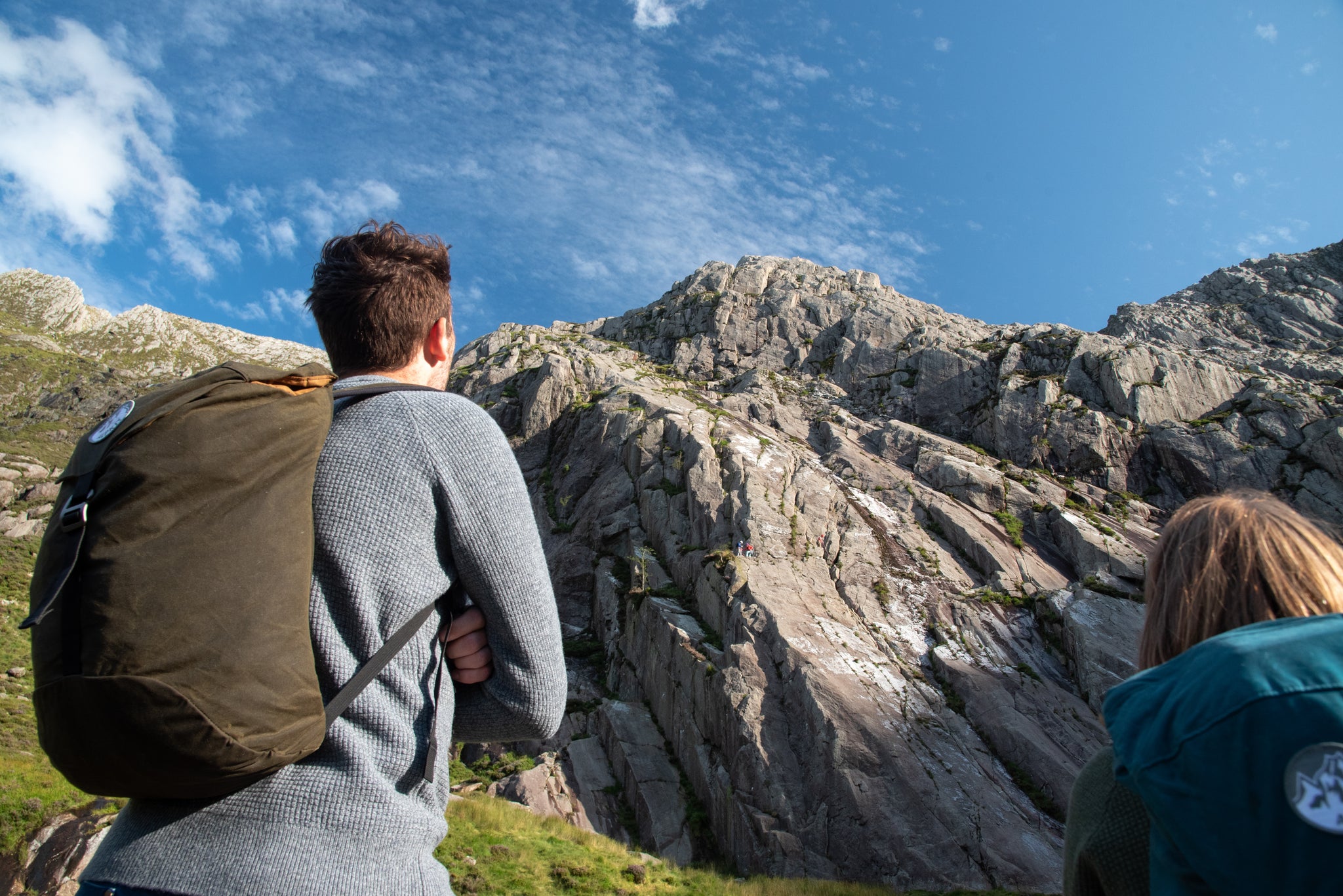 A man and a woman watching climbers on Tryfan in Eryri / Snowdonia National Park