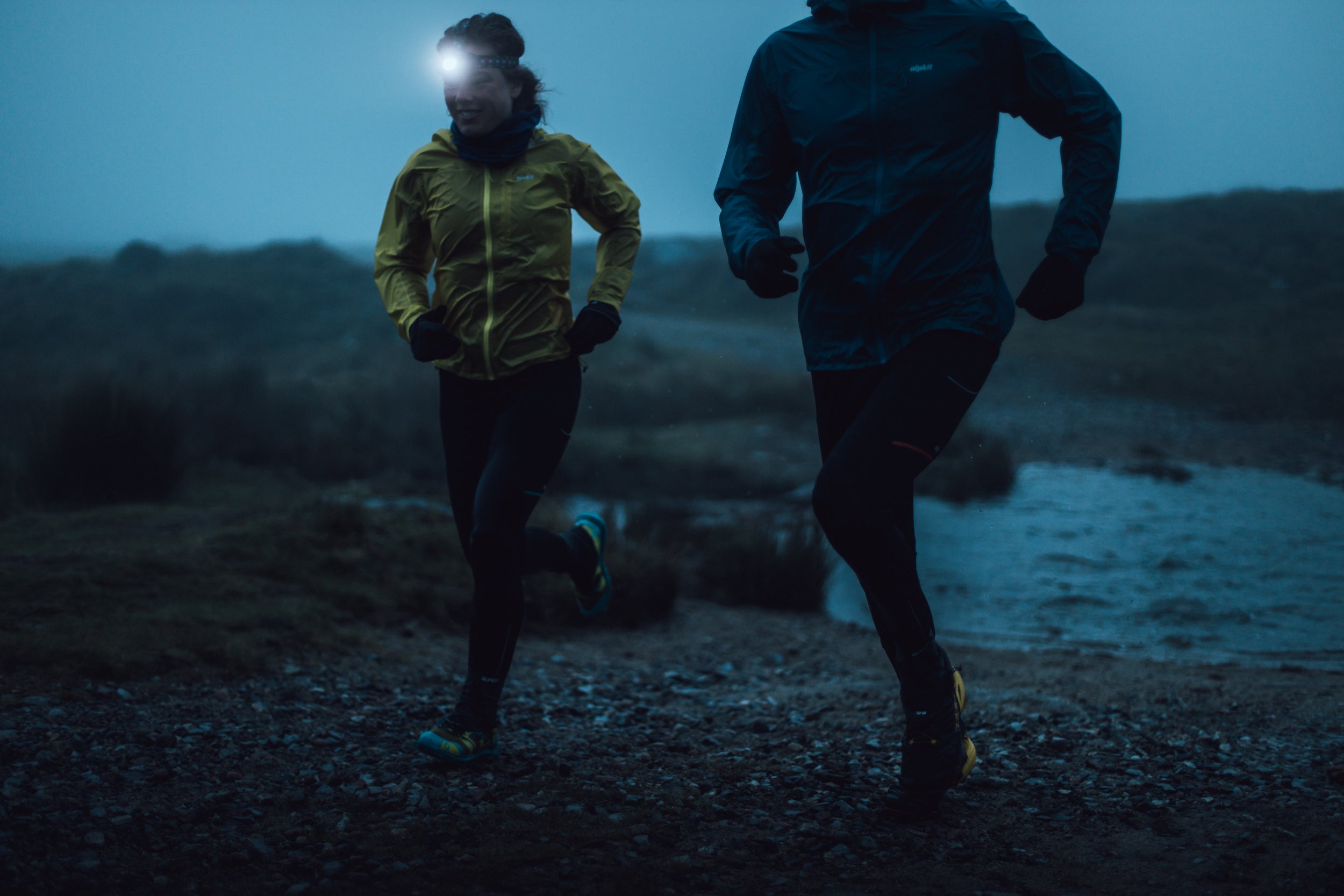 two people trail running in the dark in winter