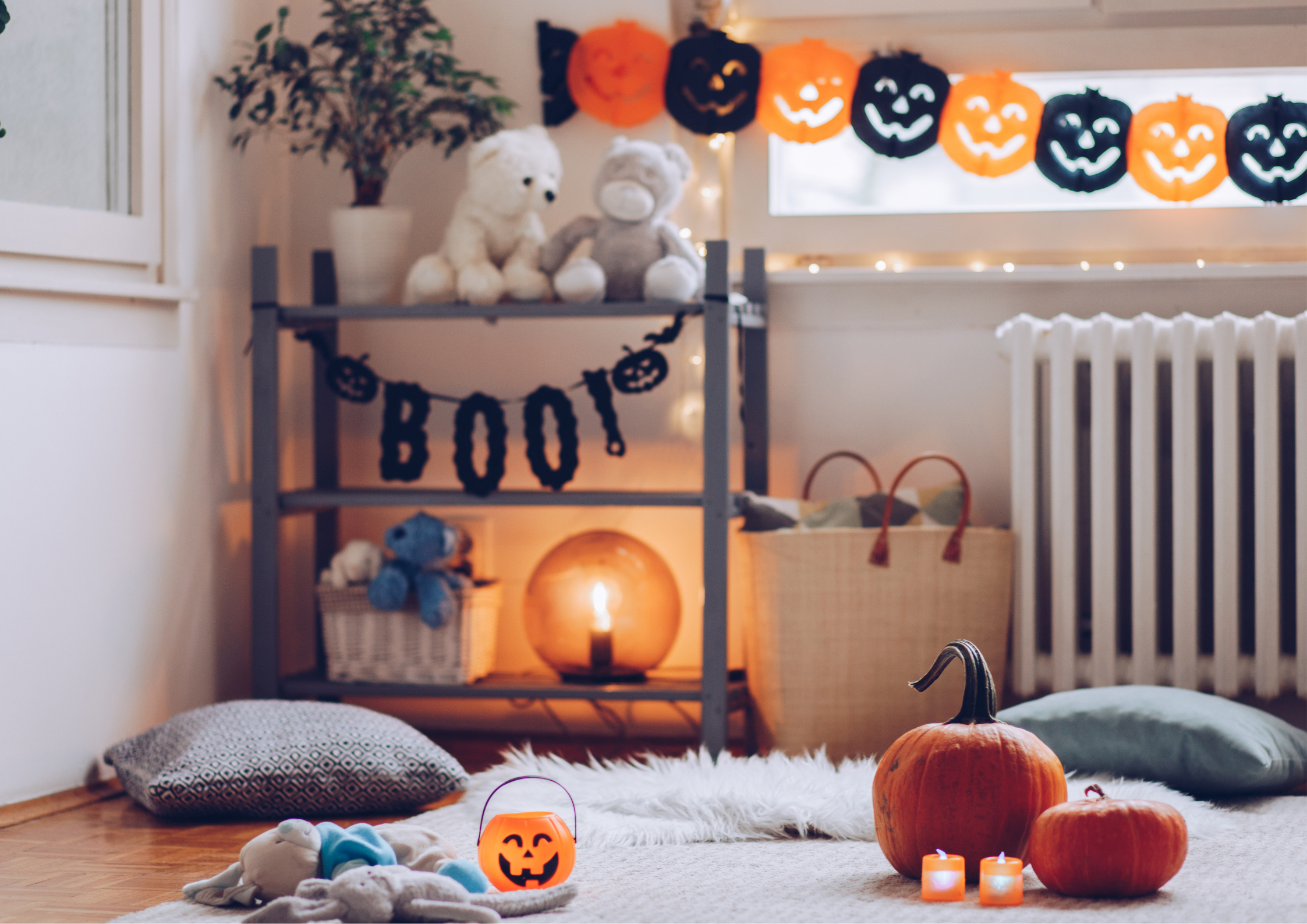 A cozy decorated living room with Halloween pumpkins, garland and candles with a white rug and white pillows around.