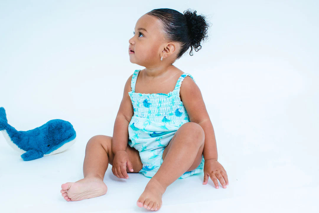 Small toddler wearing our waves bubble (light blue with dark blue waves)