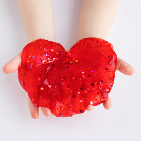 Child holding red slime full of small balls