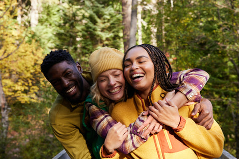 Group of friends having fun wearing eco-friendly Toad&Co among trees